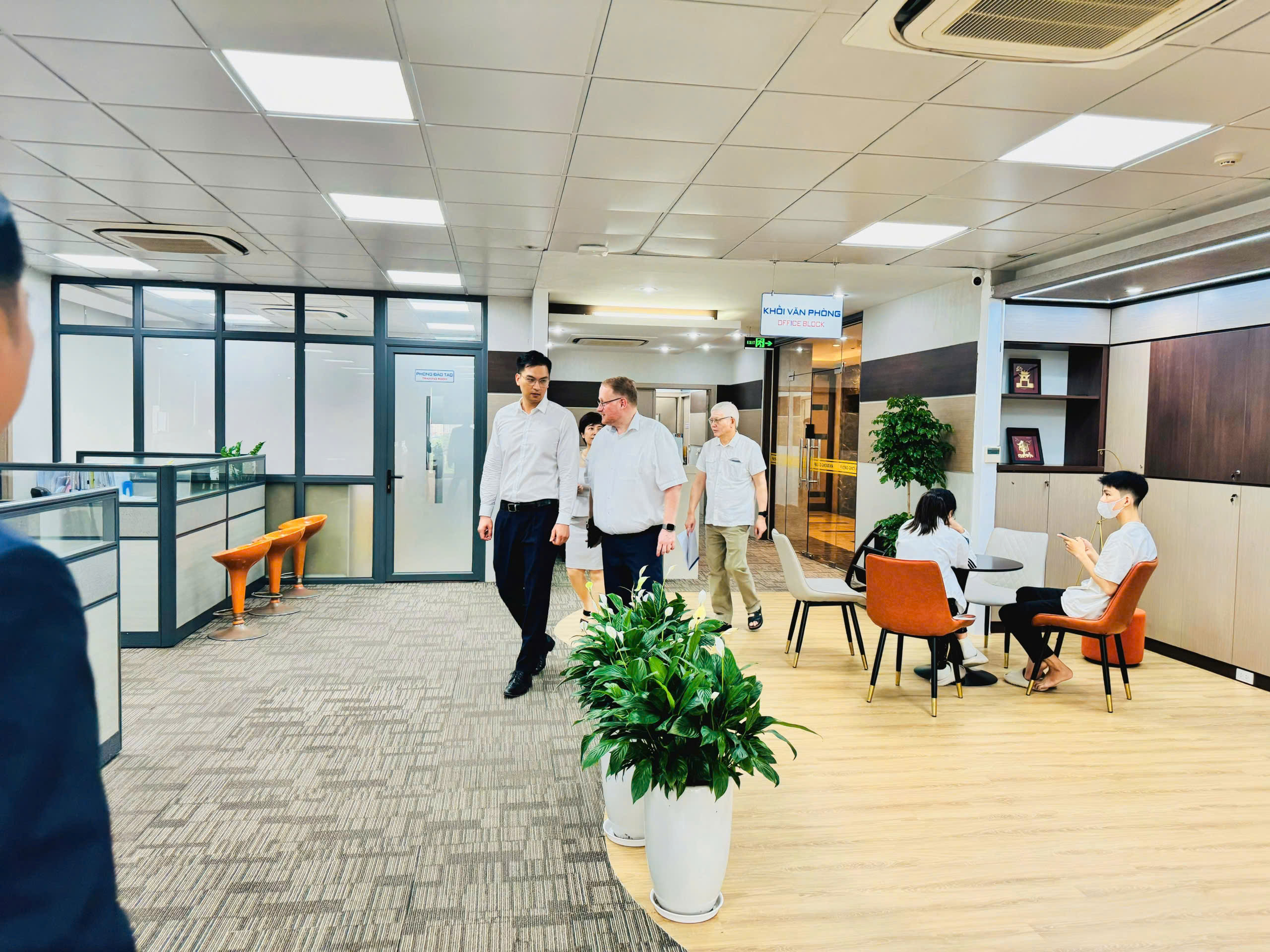 Ban lãnh đạo giới thiệu không gian làm việc của công ty với đối tác.